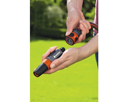 Osoba připojuje stříkací trysku ke konektoru hadice Gardena.