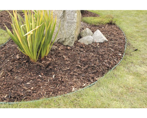 Zahradní scéna s mulčovací kůrou, kameny a obrubníkem trávníku