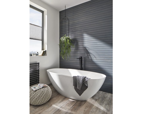 Koupelna s volně stojící vanou, ručníkem a pokojovou rostlinou