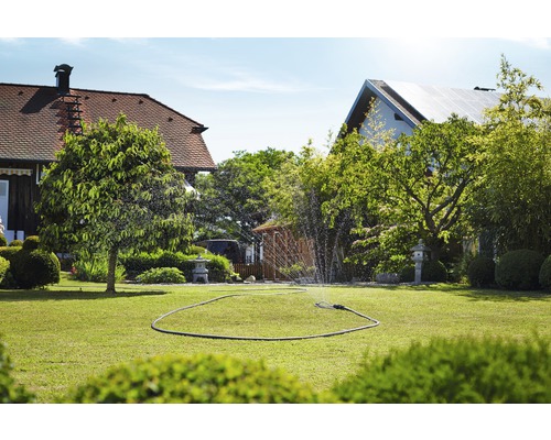 Zavlažovaný trávník se zavlažovačem trávníku na zahradě.