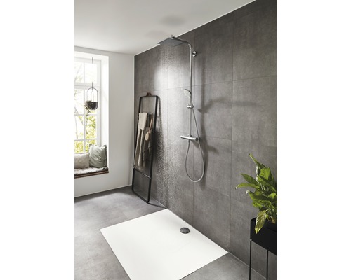 Moderní koupelna s bezbariérovým sprchovým koutem, držákem na ručníky a rostlinou