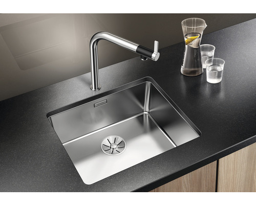 Nerezový dřez s vodovodní baterií na tmavé pracovní desce