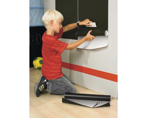 Chlapec nanáší dekorativní fólii na skříň