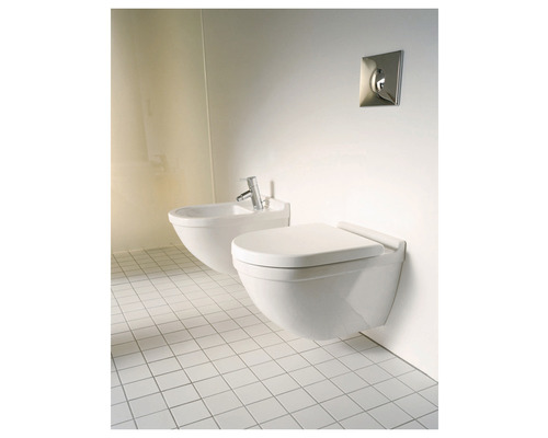 Závěsná toaleta a bidet v koupelně s bílými dlaždicemi