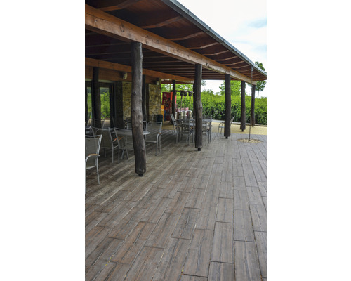 Terasa s dřevěnou podlahou a zastřešením s kmeny stromů jako podpěrami