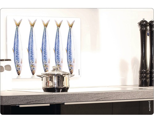 Kryt sporáku s motivem ryb a hrnec na sporáku.