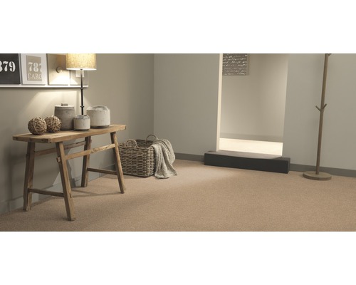 Pohled na pokoj s kobercem, dřevěným stolem a dekorativními prvky pro útulnou atmosféru.