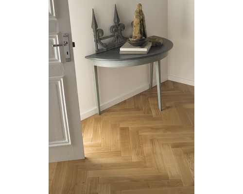 Vstupní prostor s parketami do rybí kosti, půlkruhovým stolem a dekorací