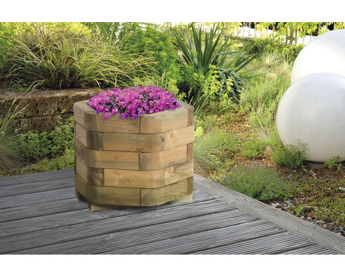 Dřevěný květináč s fialovými rostlinami v zahradě