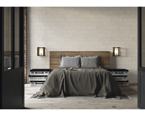 Ložnice s dřevěnou postelí, nočními stolky v designu kufru a obkladovými cihlovými dlaždicemi