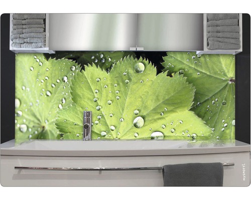 Koupelna s umyvadlem, ručníky a nástěnným panelem s listy a kapkami vody