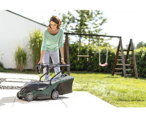 Žena montuje akumulátorovou sekačku Bosch na zahradě.