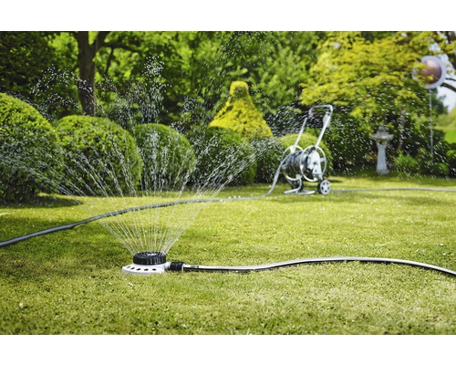 Zavlažovač trávníku zavlažuje trávník v zahradě