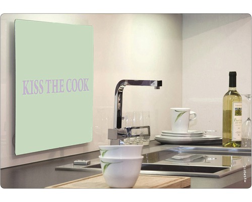 "Kuchyňská scéna s dřezem, nádobím a kuchyňskou zástěnou s textem ""Kiss the cook""."