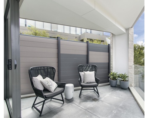 Balkon se dvěma židlemi, polštáře, malý stolek, rostliny a plot