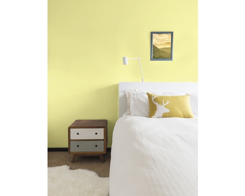 Ložnice s postelí, nočním stolkem a nástěnnou dekorací pro útulnou atmosféru.