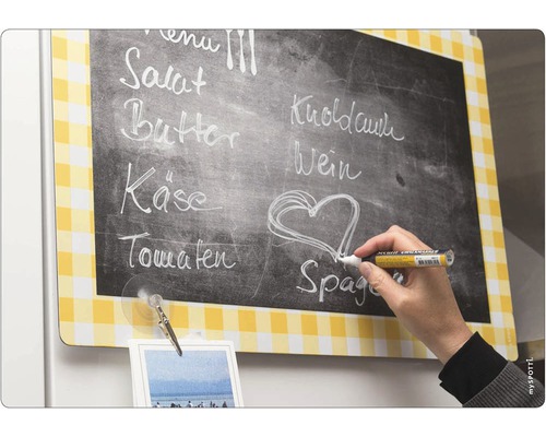 Magnetická tabule se žlutým kostkovaným vzorem a křídový popisovač v ruce