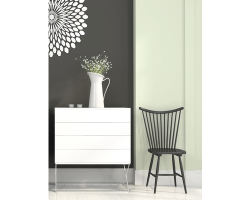 Scéna s bílou komodou, vázou s květinami a černou dřevěnou židlí.