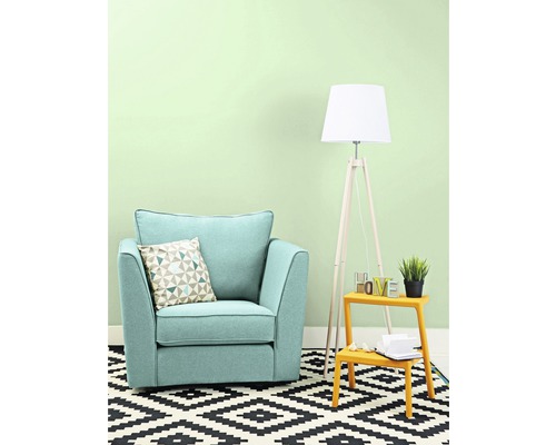 Obývací pokoj s křeslem, polštářem, stojací lampou a kobercem s geometrickým vzorem