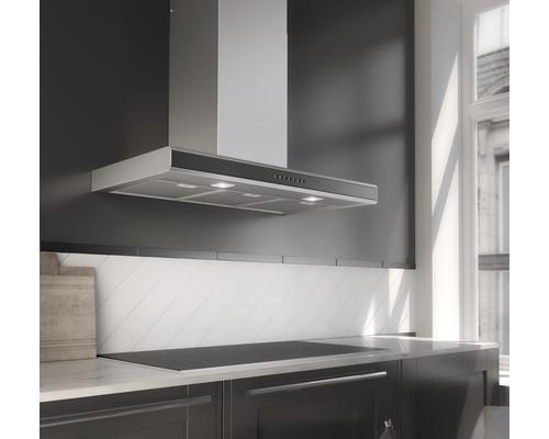 Nerezová digestoř nad varnou deskou v kuchyni.