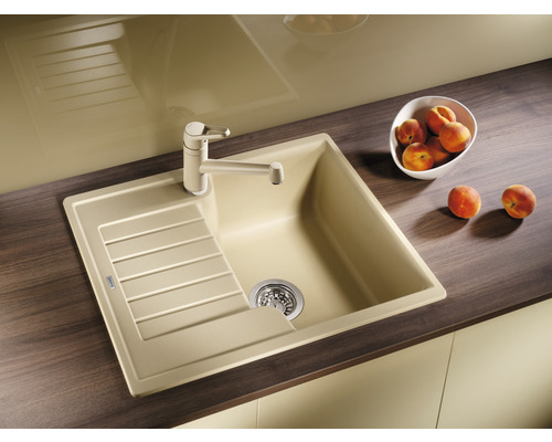 Kuchyňský dřez s odkapávací plochou a vodovodní baterií na kuchyňské lince.