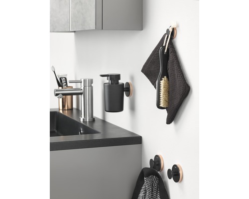 Koupelnový umyvadlový prostor s vodovodní baterií, dávkovačem mýdla, ručníky a háčky.