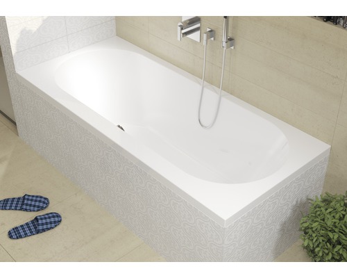 Bílá vana s vodovodní baterií a sprchovou hlavicí v koupelně