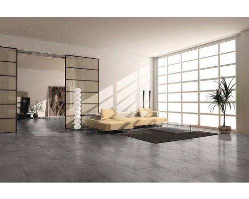 Světlý obývací pokoj s šedou dlažbou, pohovkou a velkým oknem