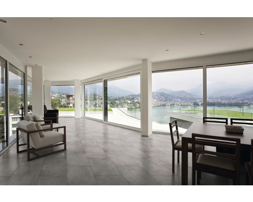 Světlá místnost s posezením, jídelním stolem a velkým panoramatickým oknem s výhledem