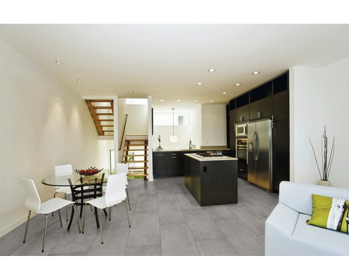 Světlá místnost s kuchyní, jídelním koutem, schodištěm a podlahovými dlaždicemi