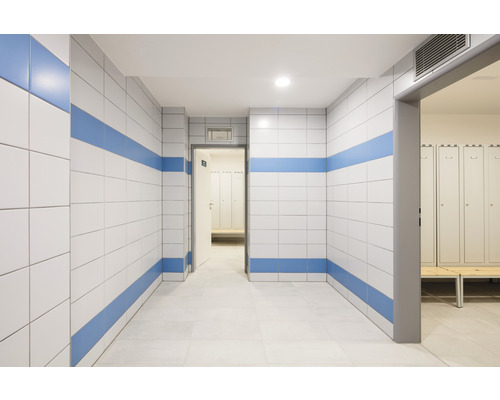 Chodba s obloženými stěnami a šatnou v pozadí