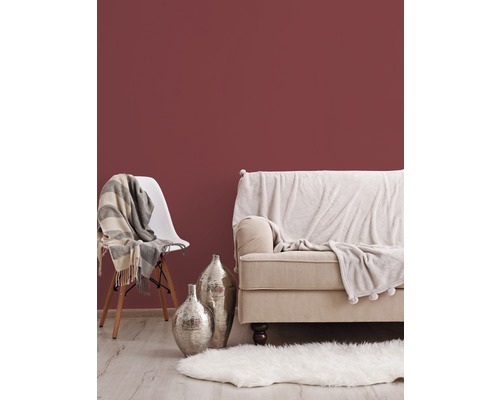 Obývací pokoj se sedačkou, židlí, kobercem a dekorací na pozadí zdi