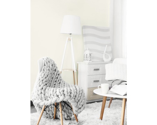 Obývací pokoj se židlí, pletenou dekou, stojací lampou, odkládacím stolkem a komodou