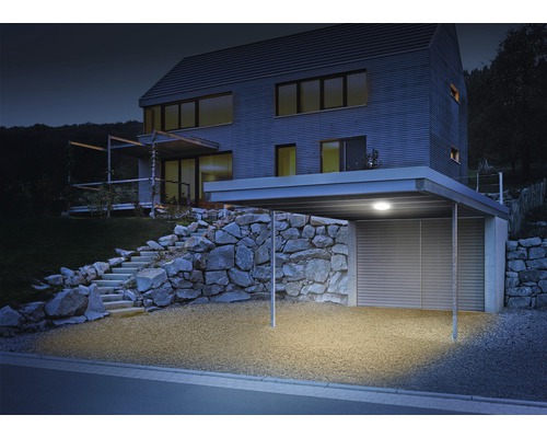 Osvětlený přístřešek pro auto u moderního domu s kamenným schodištěm