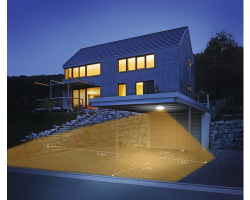 Moderní dům s přístřeškem pro auto a venkovním světlem s pohybovým senzorem, které osvětluje plochu 2,8 metru.