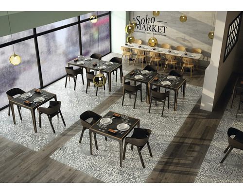Interiér restaurace se stoly, židlemi a dekorativní podlahovou dlažbou.