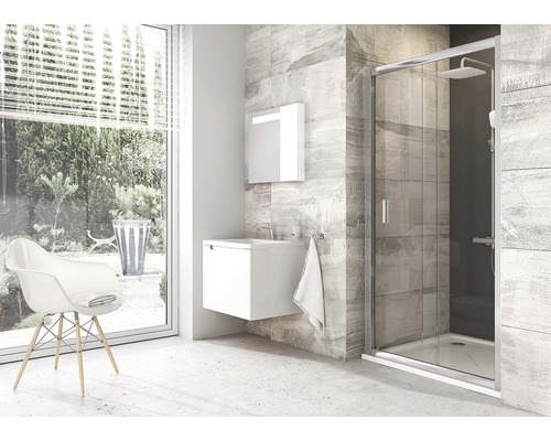 Moderní koupelna se sprchou, umyvadlem, zrcadlovou skříňkou a židlí u okna.