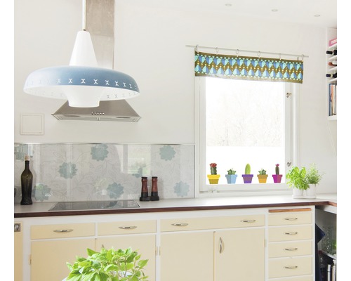 Světlá kuchyně se závěsnou lampou, digestoří, okenní dekorací a hrnkovými rostlinami.