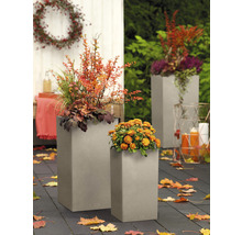 Dva osázené plastové květináče na zahradě.