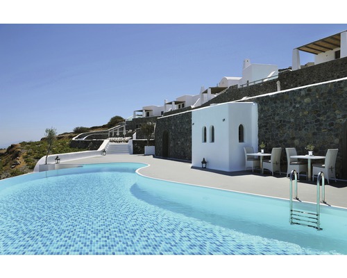 Vnější pohled na hotel s bazénem, posezením a bílou fasádou