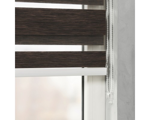 Detailní záběr hnědé dvojité rolety na okně s ovládacím řetízkem