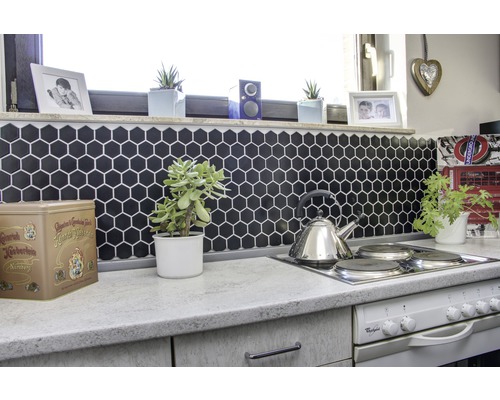 Kuchyňská scéna s šestiúhelníkovými dlaždicemi, čajovou konvicí a pokojovými rostlinami