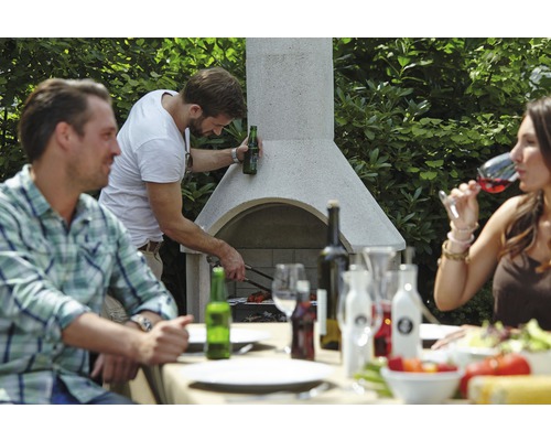 Lidé grilují na zahradním grilu a sedí u jídelního stolu