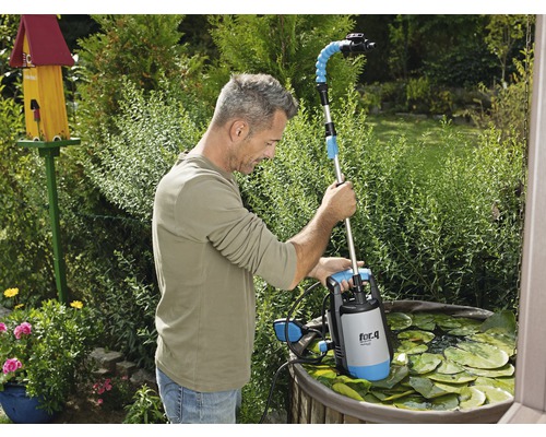 Muž používá kalové čerpadlo do jezírka značky for.q v zahradním jezírku
