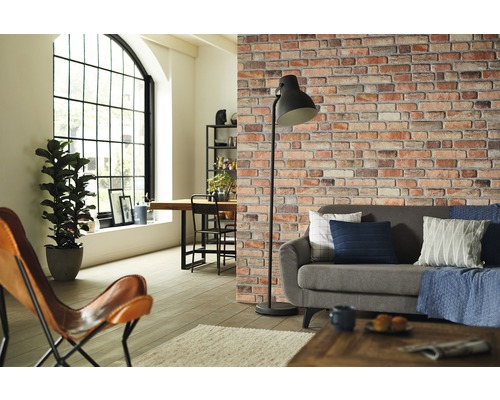 Obývací pokoj s pohovkou, stojací lampou a tapetou imitující cihlovou zeď