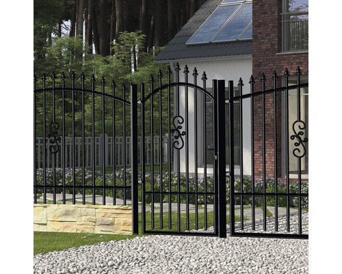 Černá zahradní brána a plot s ozdobnými prvky před obytným domem.