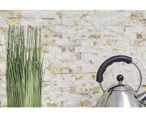 Dekorativní kamenná zeď s okrasnou trávou a nerezovou varnou konvicí