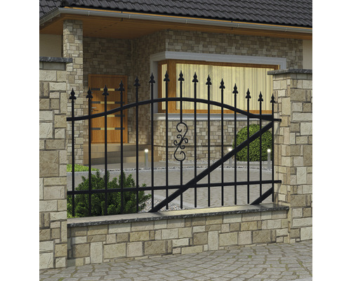Černý kovový plot před domem s kamennou zdí