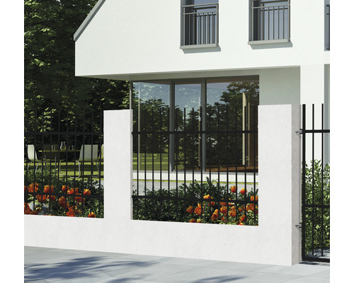Černý kovový plot s betonovými sloupky před domem.
