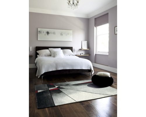 Ložnice s postelí, kobercem a dekorací v moderním designu